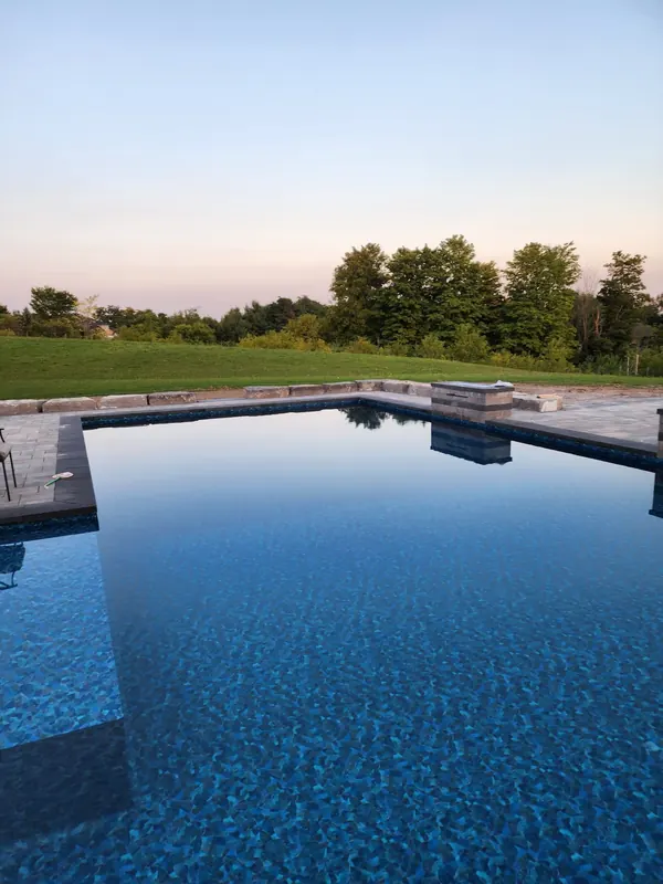 Pool with stone deck at dusk
