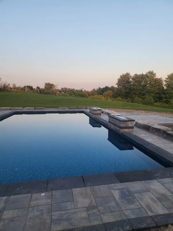 Pool with stone feature columns at sunset